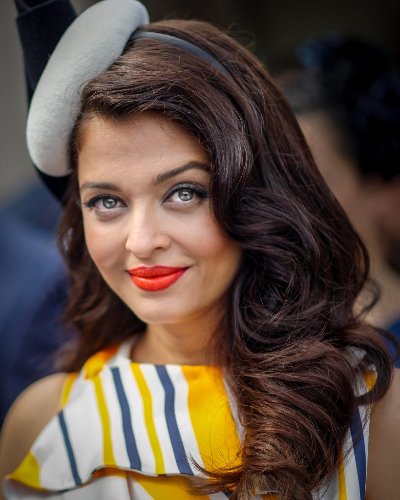 Aishwarya Rai Bachchan with red lipstick and a grey fascinator at Royal Randwick racecourse in Sydney