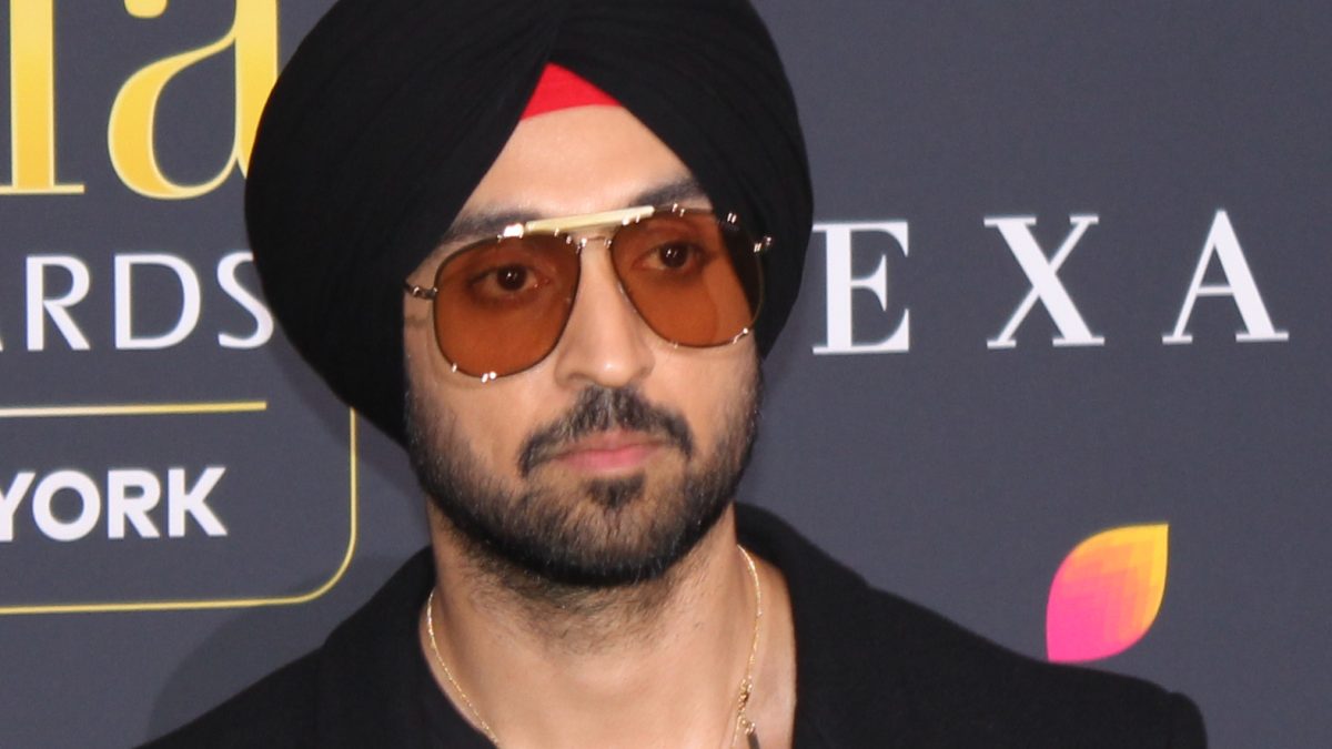 Diljit Dosanjh in a black turban and tinted aviator sunglasses on the green carpet at the IIFA Awards
