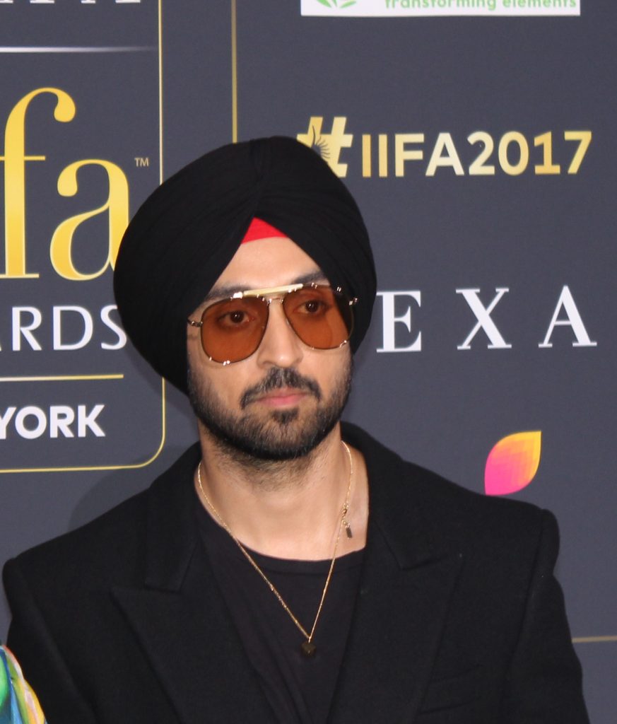 Diljit Dosanjh in a black turban and tinted aviator sunglasses on the green carpet at the IIFA Awards