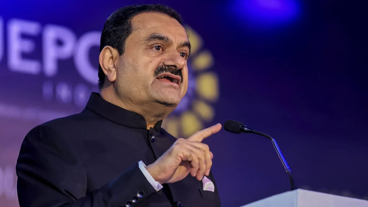 Gautam Adani speaking at a podium and gesturing with his hand