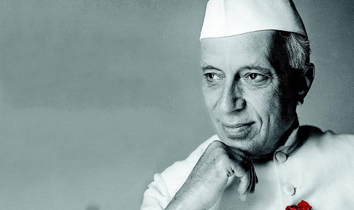 Black-and-white portrait of Jawaharlal Nehru in a Gandhi cap with a red rose on his jacket