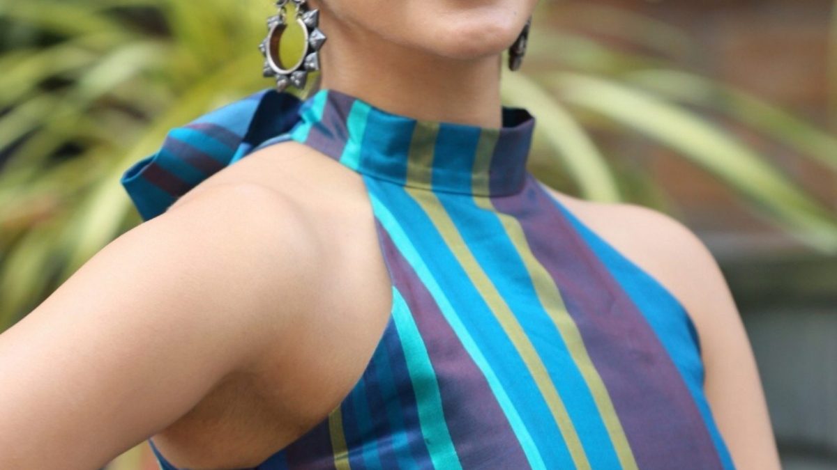 Kiara Advani smiling with hoop earrings and a striped halter top