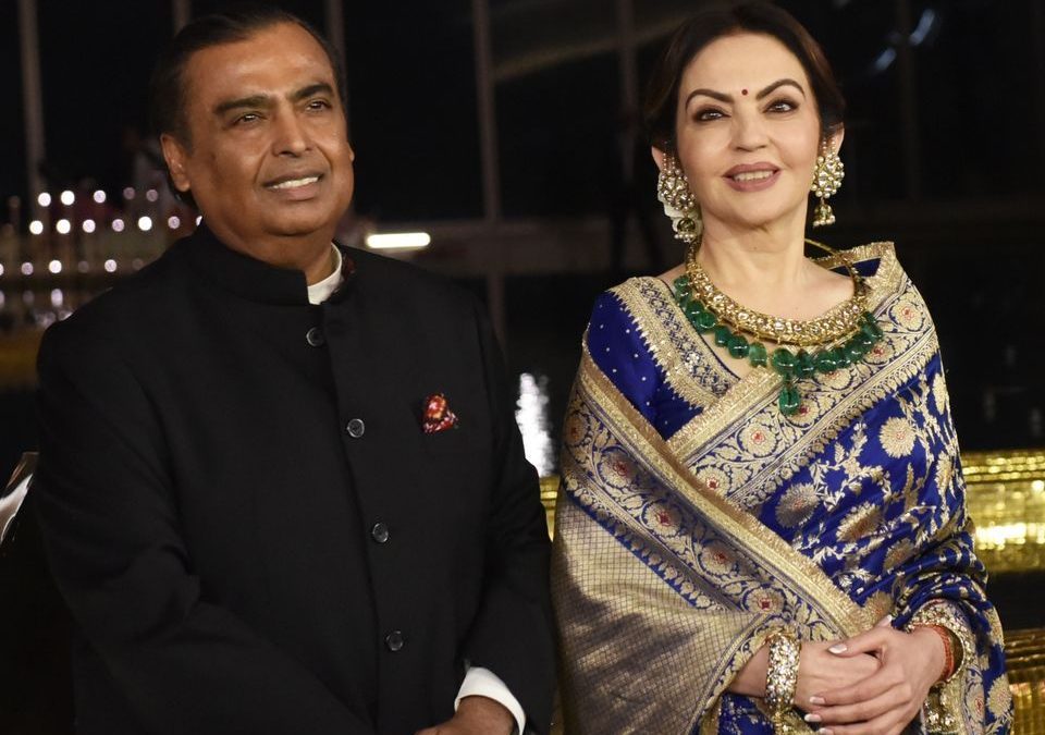 Mukesh Ambani and Nita Ambani standing together at an evening event