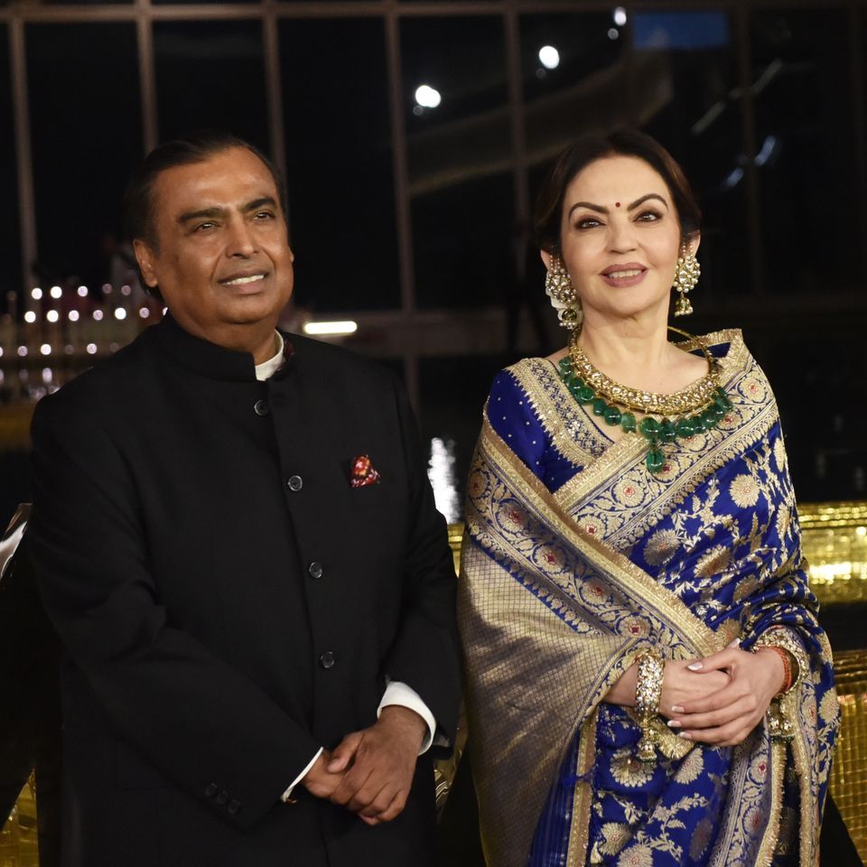 Mukesh Ambani and Nita Ambani standing together at an evening event
