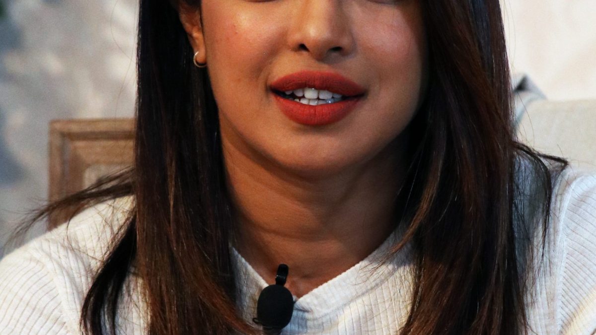 Priyanka Chopra Jonas in a white sweater speaking at the Global Education and Skills Forum in Dubai