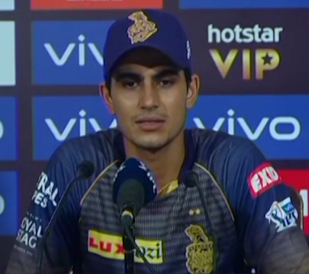 Shubman Gill in a Kolkata Knight Riders cap and jersey speaking at a press conference