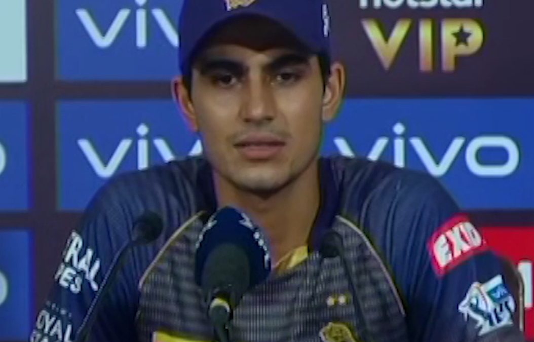 Shubman Gill in a Kolkata Knight Riders cap and jersey speaking at a press conference