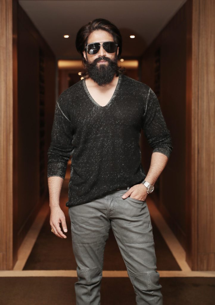 Yash with long hair, a full beard and sunglasses wearing a dark sweater