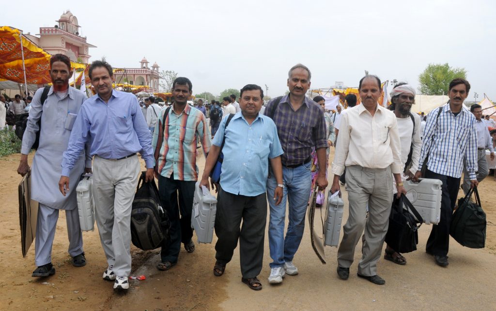 Polling officials carrying electronic voting machines and election materials in Jaipur