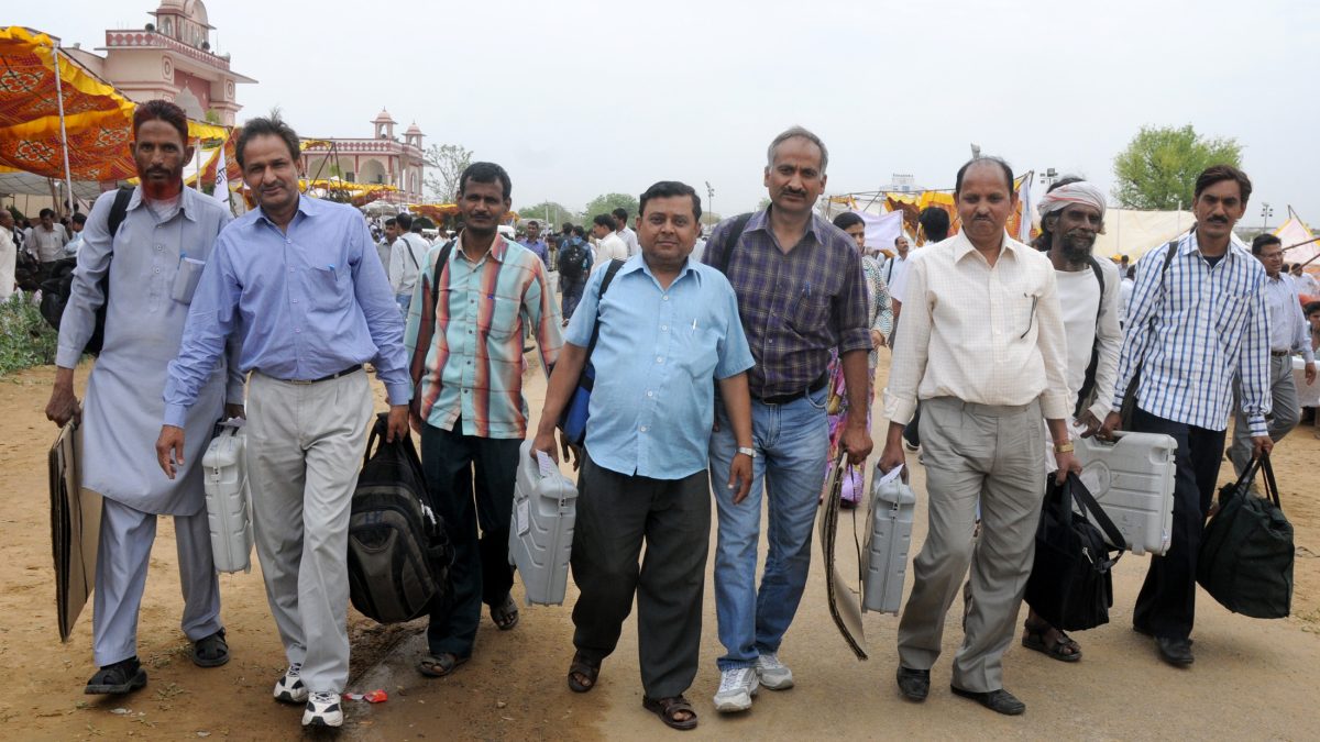 Polling officials carrying electronic voting machines and election materials in Jaipur