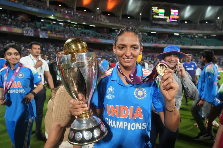 Harmanpreet Kaur holding the trophy and a medal in India colours