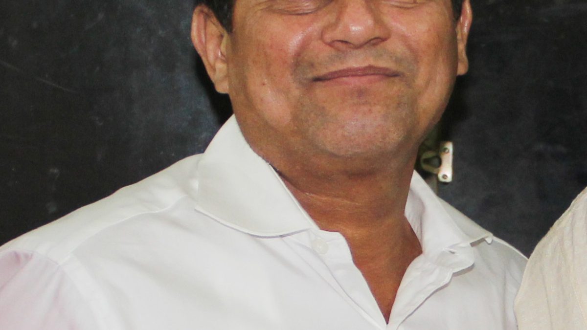 Achyuta Samanta in a white shirt, smiling