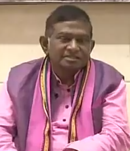 Ajit Jogi seated, in a pink kurta and purple waistcoat