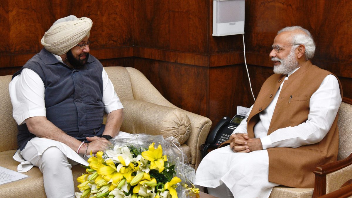 Amarinder Singh in a turban and waistcoat seated in conversation with Prime Minister Narendra Modi