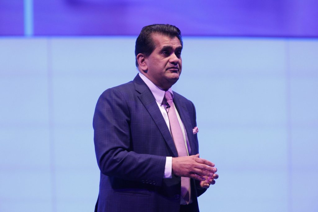 Amitabh Kant in a blue suit speaking on stage