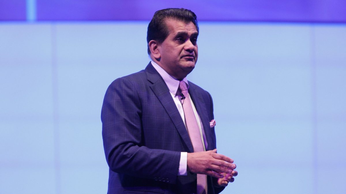 Amitabh Kant in a blue suit speaking on stage