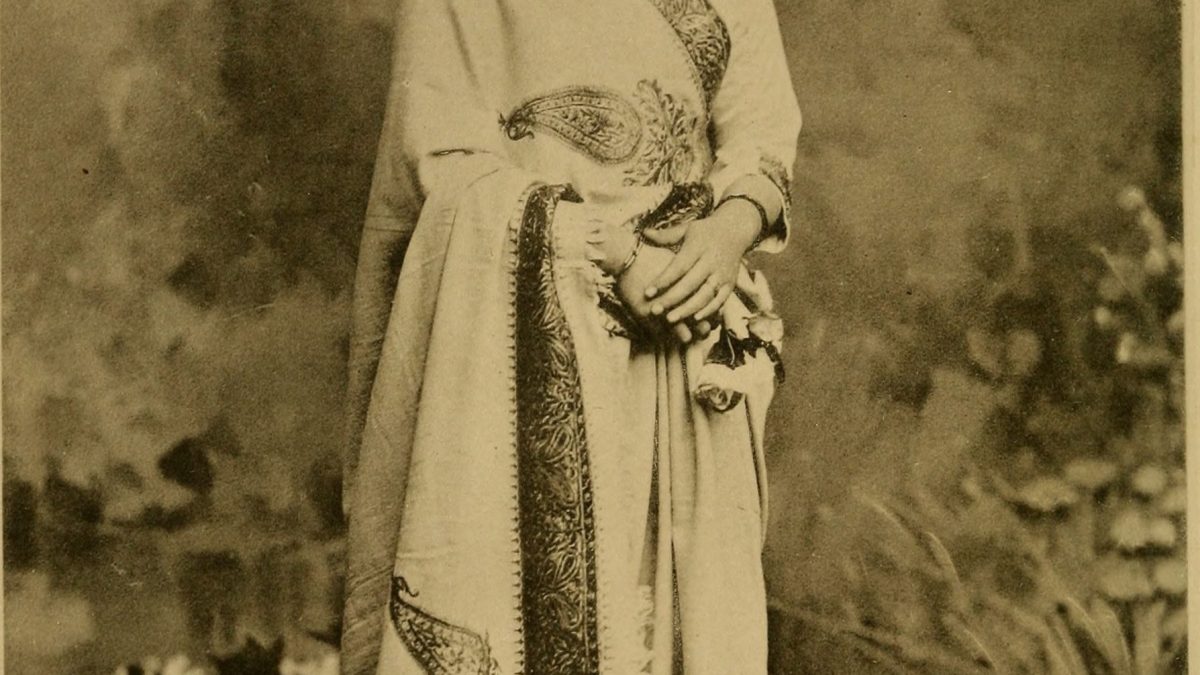 Sepia studio photograph of Anandibai Joshi standing in a sari and shawl