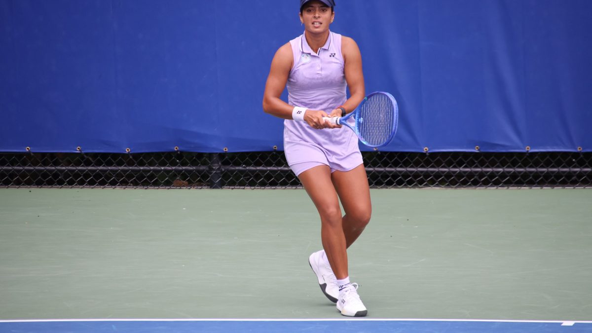 Ankita Raina in a lilac tennis dress and cap, holding her racket on court