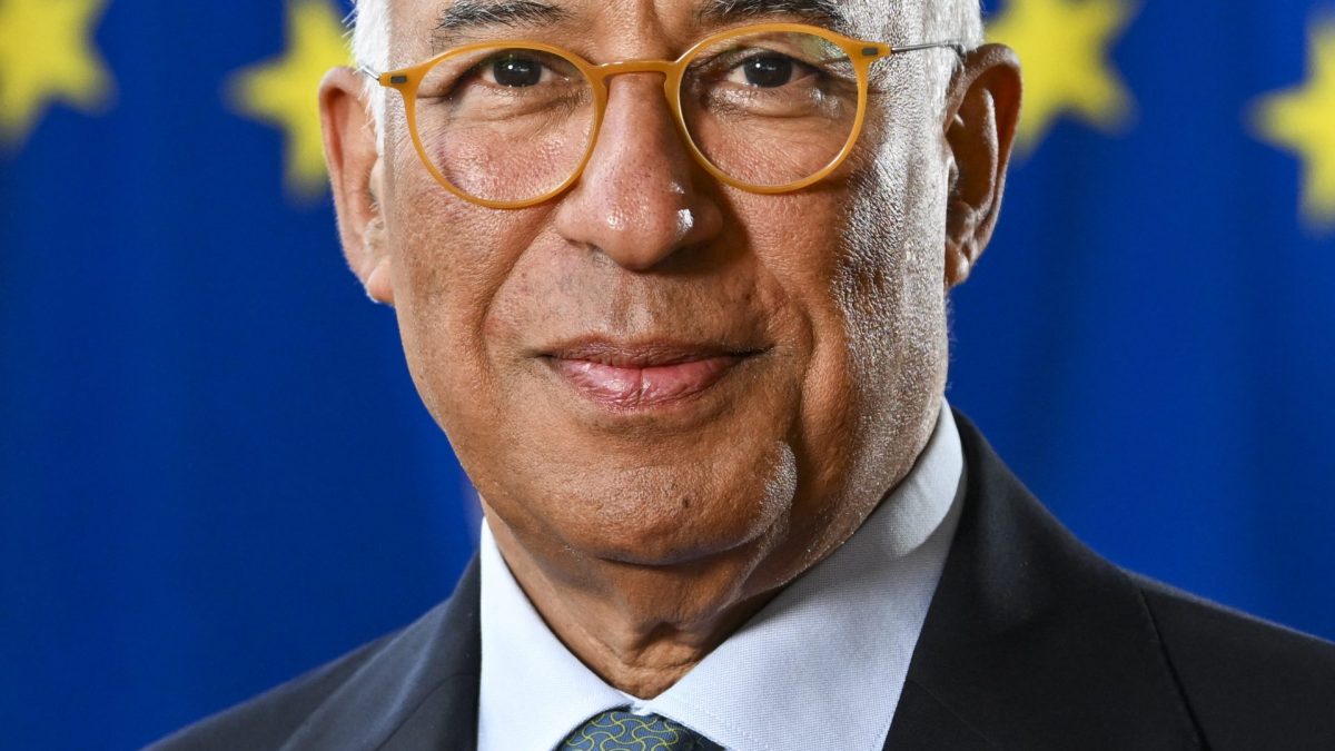 Portrait of António Costa in glasses and a dark suit, smiling