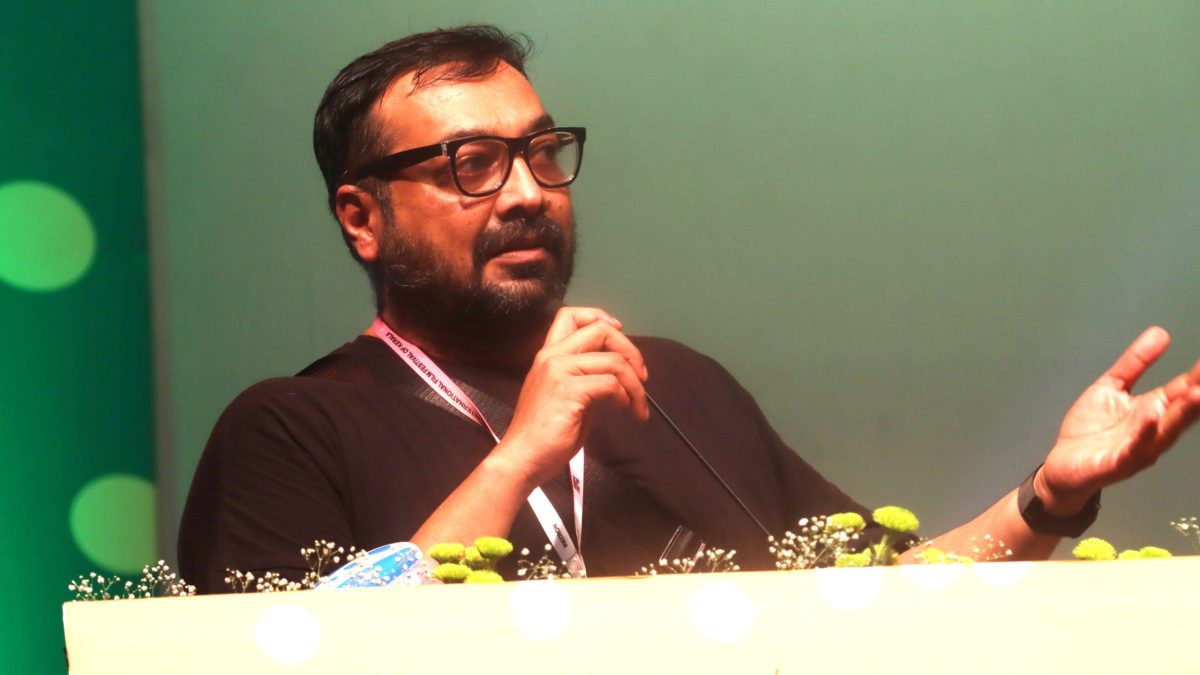 Anurag Kashyap with a beard and glasses, in a dark T-shirt, speaking into a microphone