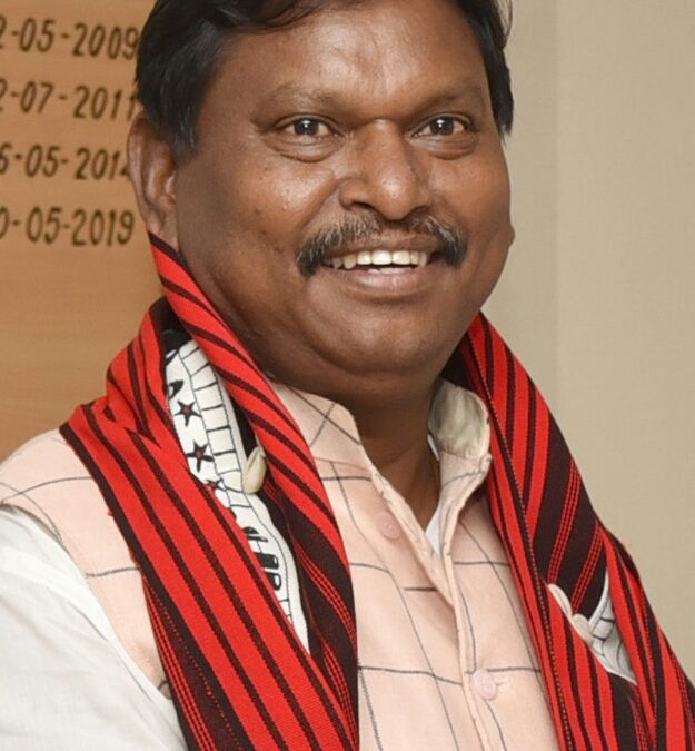 Arjun Munda smiling, with a red and black tribal stole