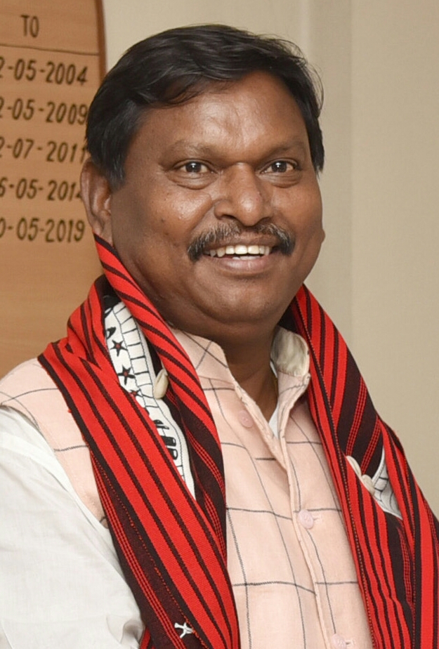 Arjun Munda smiling, with a red and black tribal stole