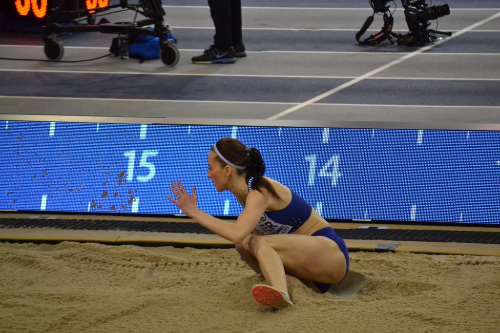 A triple jumper landing in the sand pit
