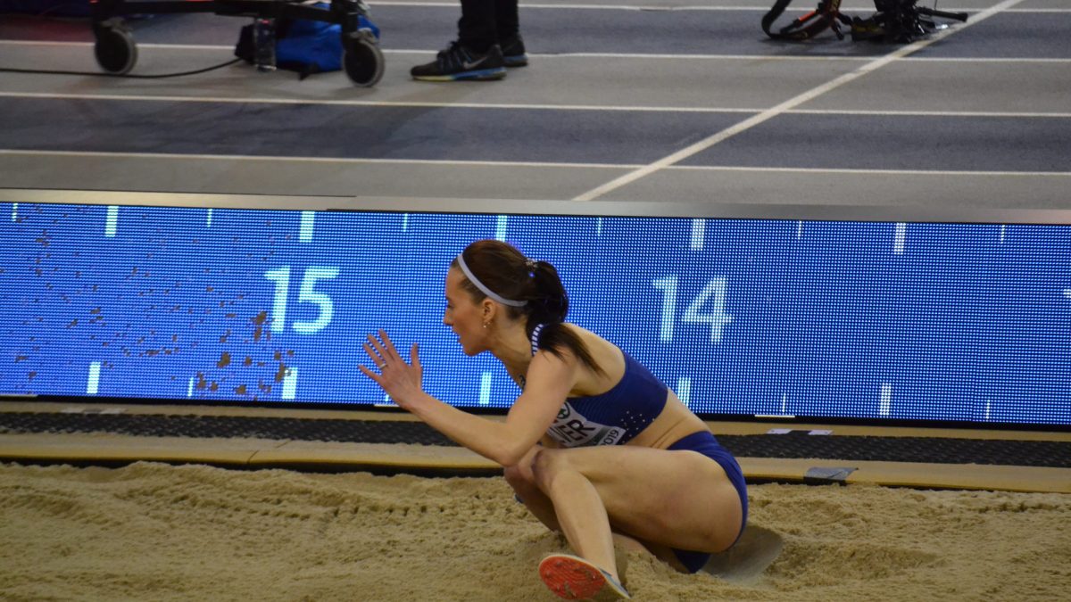 A triple jumper landing in the sand pit