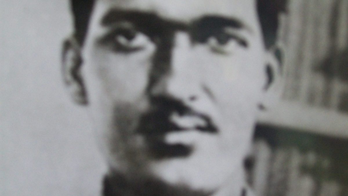 Black-and-white photograph of a young Ashfaqulla Khan in an open-collared shirt