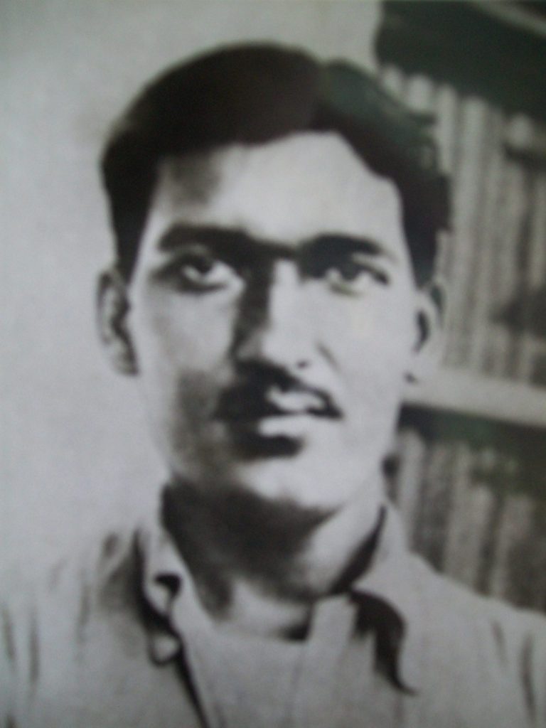Black-and-white photograph of a young Ashfaqulla Khan in an open-collared shirt