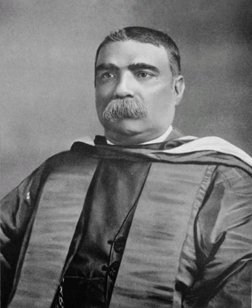 Black-and-white portrait of Ashutosh Mukherjee with a heavy moustache, in academic robes