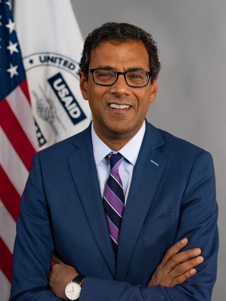 Official portrait of Atul Gawande in glasses and a dark suit