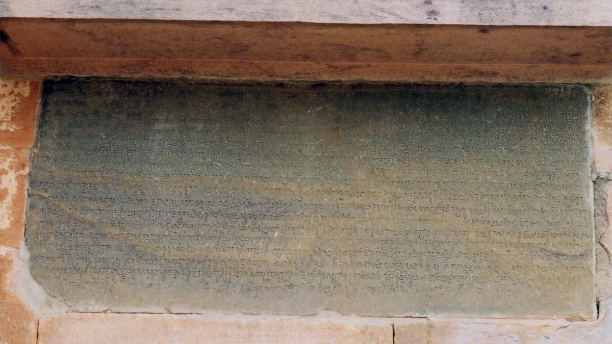 A stone slab covered with lines of old Kannada script set in the wall of the Meguti temple at Aihole