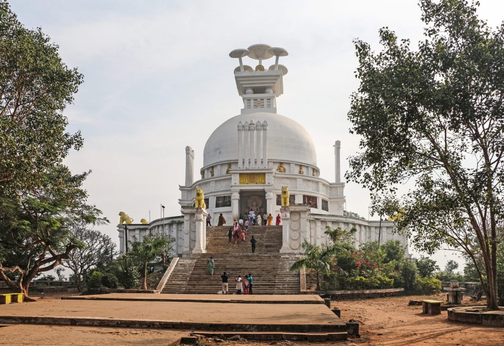 The white dome of the Shanti Stupa on Dhauli hill in Odisha with visitors on its steps