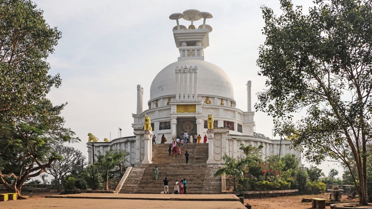 The white dome of the Shanti Stupa on Dhauli hill in Odisha with visitors on its steps
