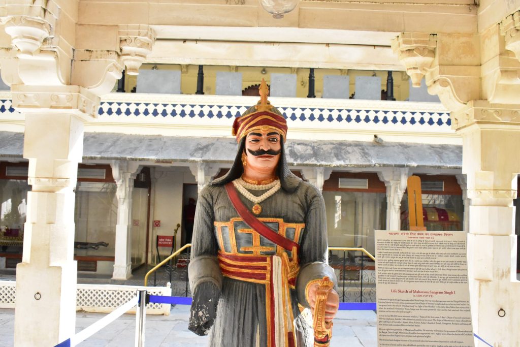 A painted statue of Rana Sanga in armour and turban standing in a courtyard of the City Palace in Udaipur