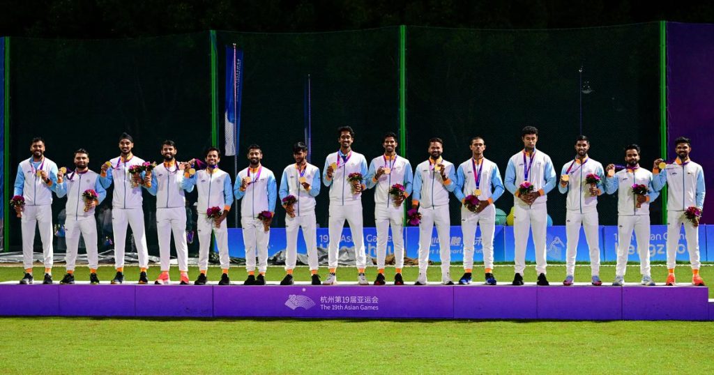 Members of the Indian men's cricket team holding gold medals on a podium at the Asian Games