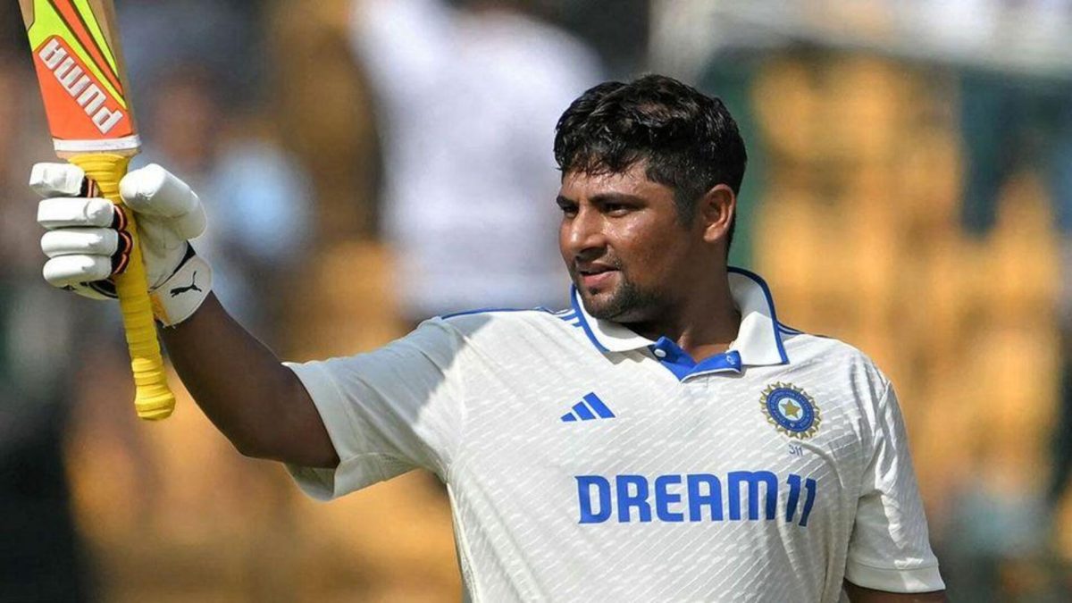 An Indian Test batter raising his bat after reaching a century