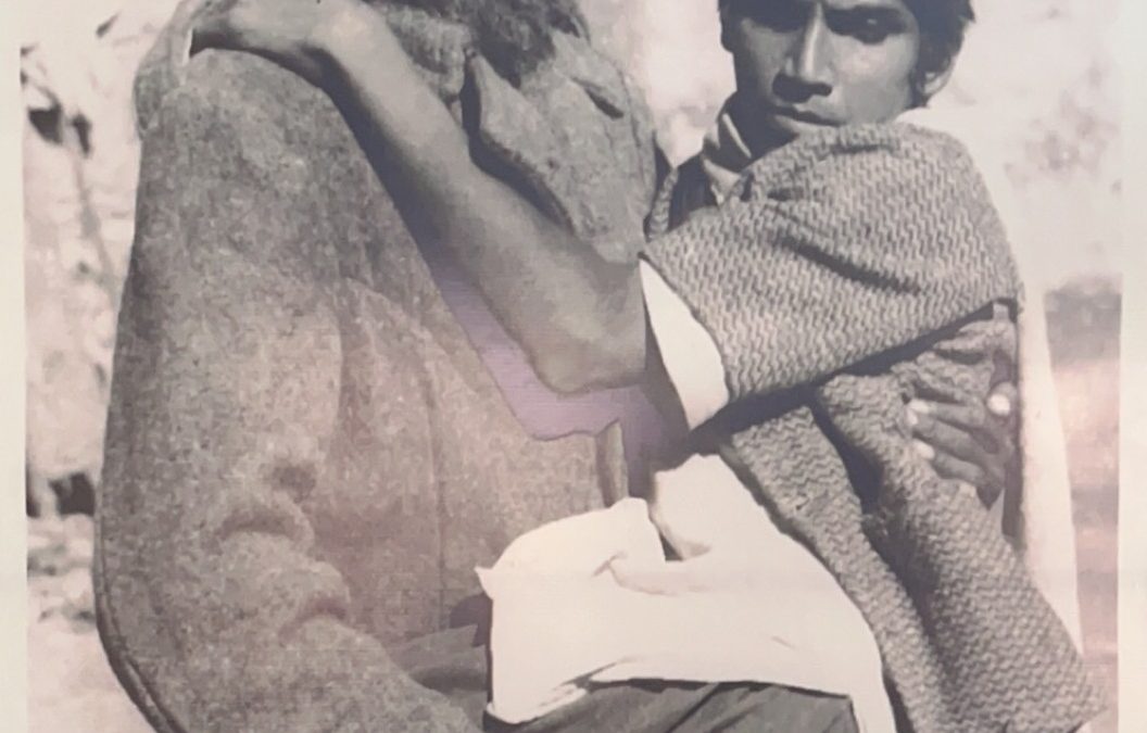 Bhagat Puran Singh, bearded and in rough clothes, carrying a disabled young man in his arms