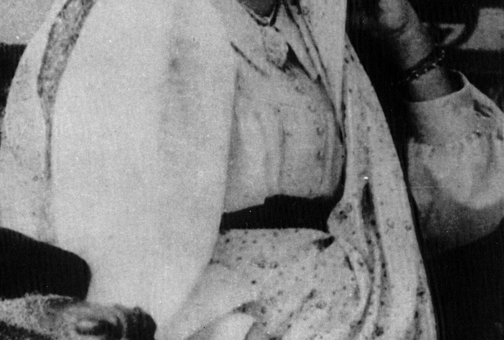 Bhikaiji Cama seated, wearing a sari draped over her head in the Parsi style
