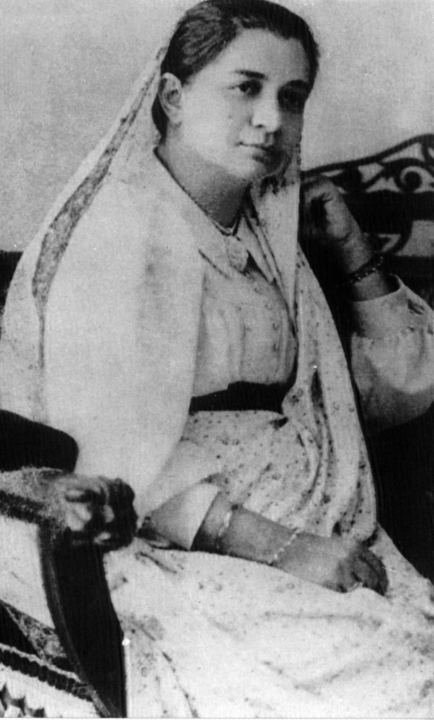 Bhikaiji Cama seated, wearing a sari draped over her head in the Parsi style