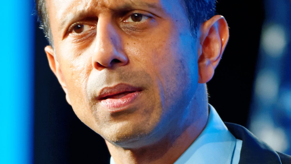 Bobby Jindal in a suit speaking at a lectern