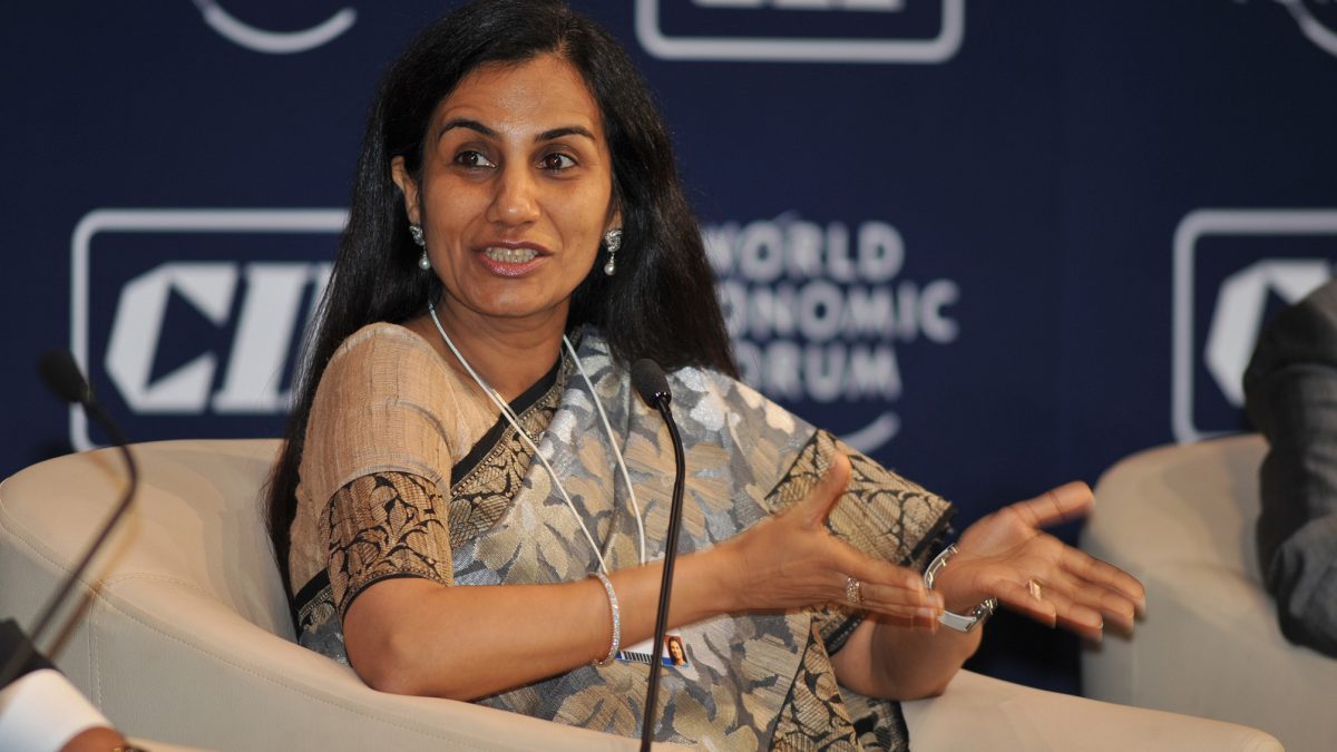 Chanda Kochhar in a sari seated on stage, gesturing as she speaks