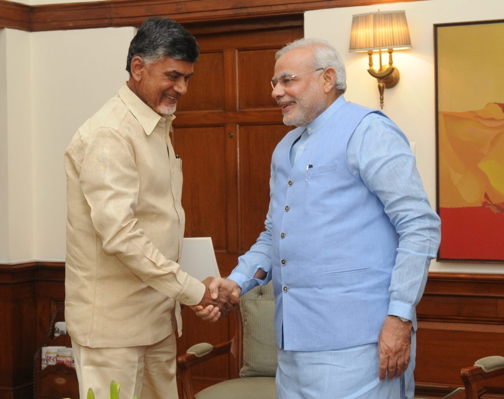 Chandrababu Naidu in a cream shirt shaking hands with Prime Minister Narendra Modi