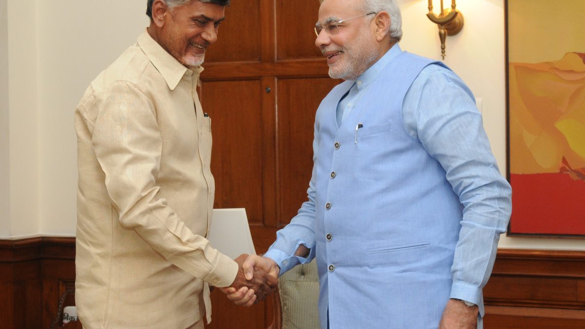 Chandrababu Naidu in a cream shirt shaking hands with Prime Minister Narendra Modi