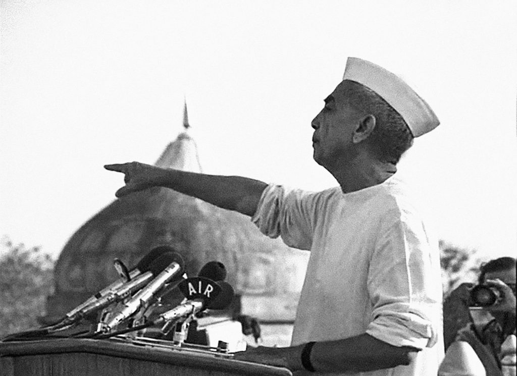 Black and white photo of Charan Singh in a Gandhi cap speaking from the Red Fort
