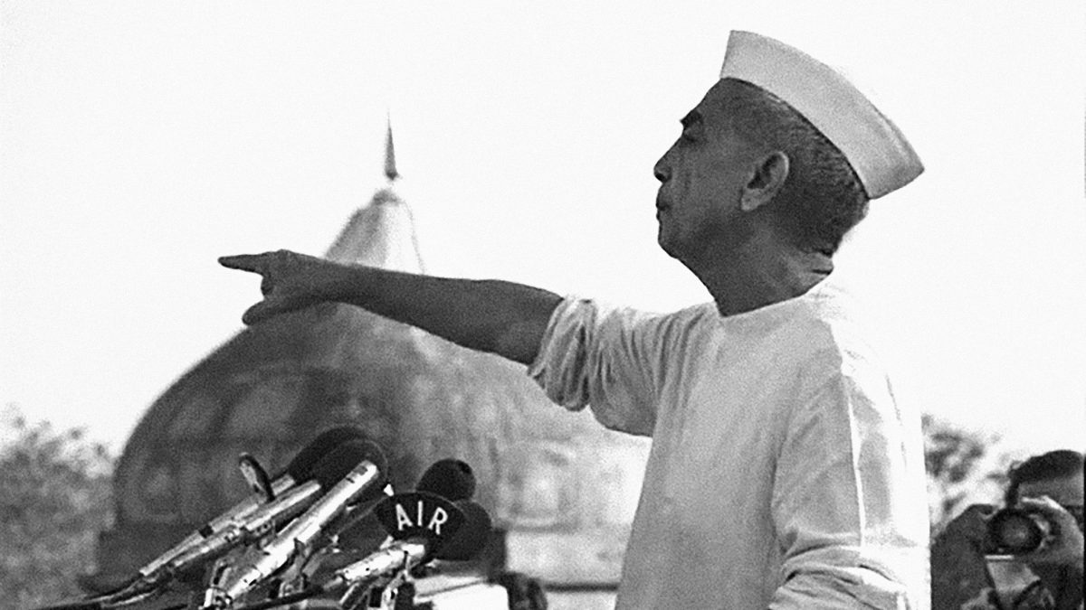 Black and white photo of Charan Singh in a Gandhi cap speaking from the Red Fort