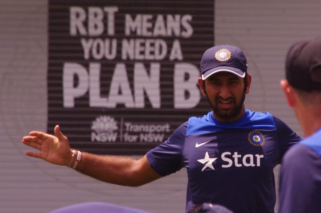 Cheteshwar Pujara in a blue India cap and training shirt, gesturing during practice