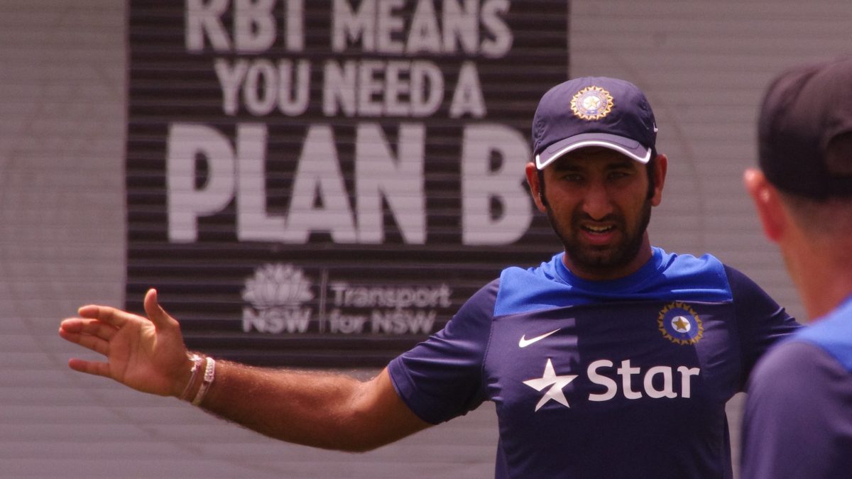 Cheteshwar Pujara in a blue India cap and training shirt, gesturing during practice