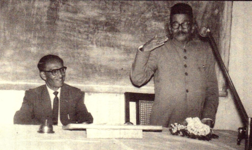 A black-and-white photograph of D. R. Bendre and H. S. Krishnaswamy Iyengar at a table during a function